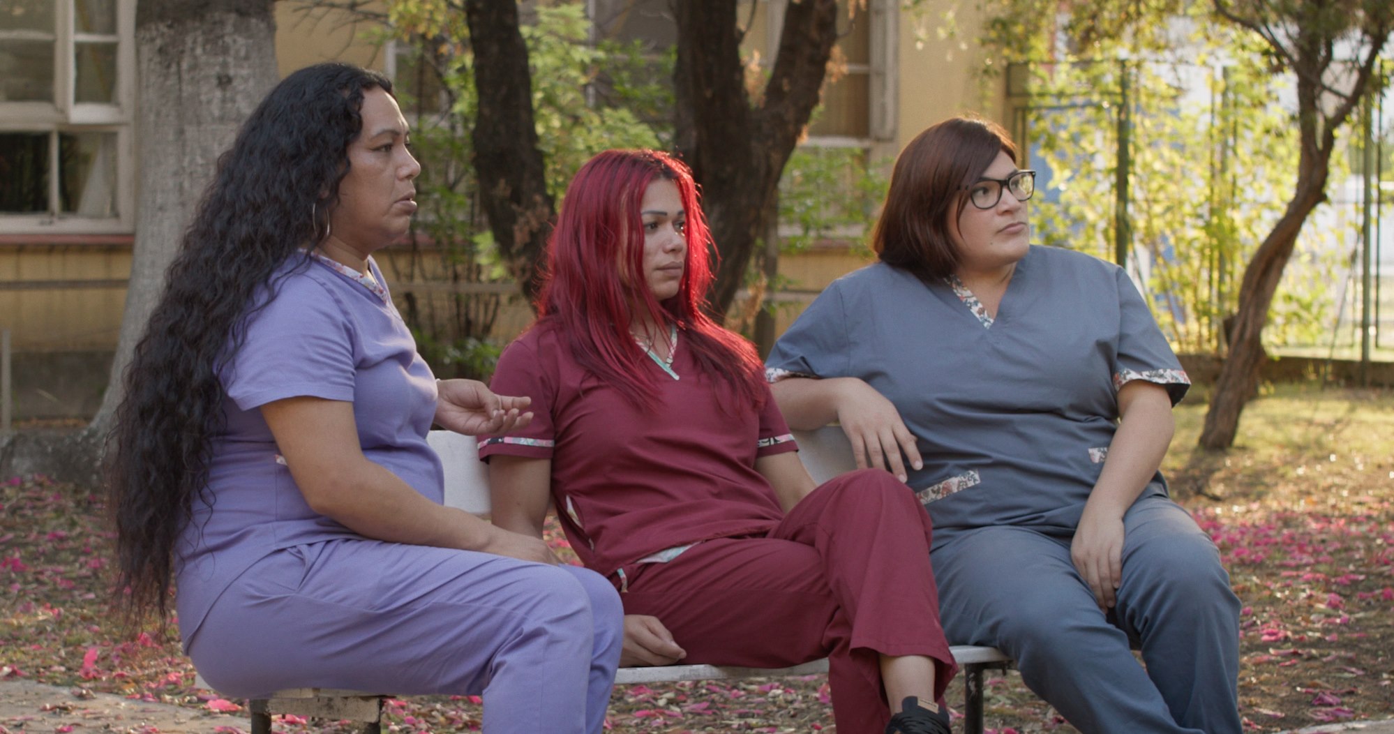 Fotograma de Cuidadoras: tres mujeres sentadas al aire libre